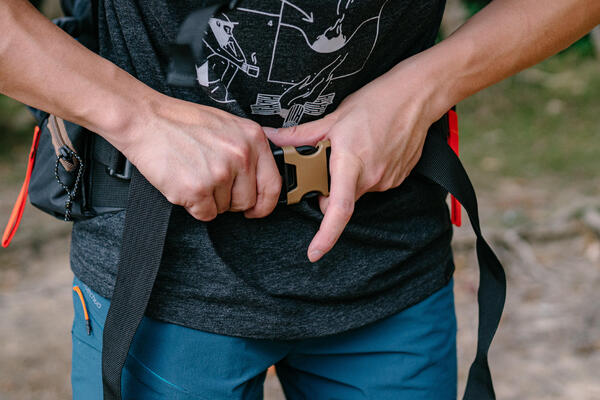 Before adjusting: sling backpack over shoulder, loosen all straps